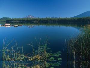 Big Lava Lake is a deep blue with tall grass and lilypads along its bank