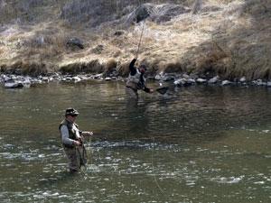 A man stands in the Crooked River fly-fishing