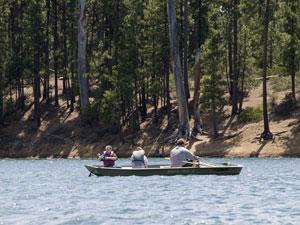 A man and two children fish from a small boat on South Twin Lake