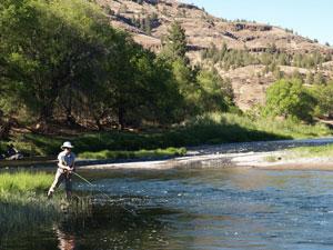 A person has a fishing line in the water of the John Day River