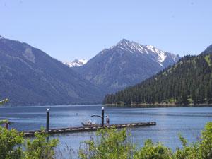 a dock extends into Wallowa Lake and mountains rise in the background