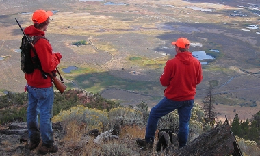 image of two deer hunters on a ridge scanning countryside