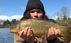 angler holding a large common carp