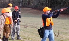 Shooter lines up a shot while instructor looks on from behind