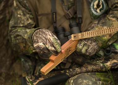 image of a hunter using a box call to call a turkey
