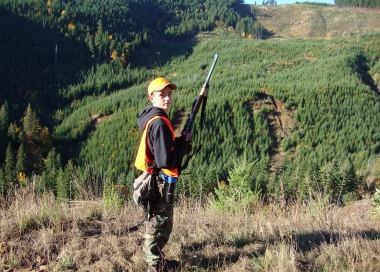 young hunter overlooking a mixed age forest landscape