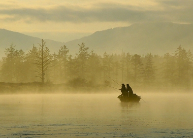two anglers in a boat in the morning fog