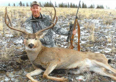 Hunter with nice mule deer in a grassy field in southeast Oregon