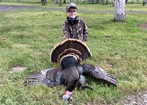 Young hunter poses with a wild turkey