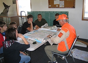 Hunter ed students around a table reading a map