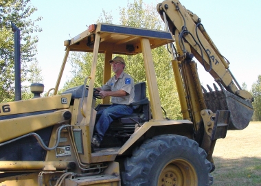 A volunteer maneuvers a tractor