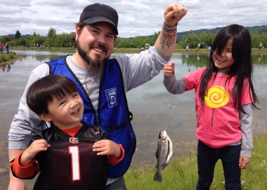 Volunteer fishing instructor with two young students