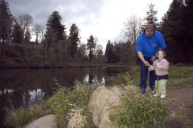 A father and young daughter pose on the bank of Mt. Hood Pond