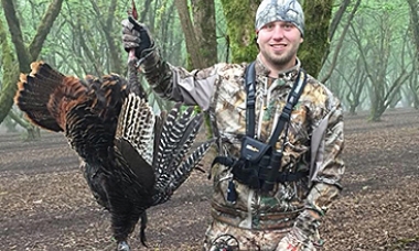 image of a hunter holding up a turkey