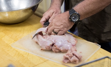 image of a cook in the kitchen preparing turkey meat