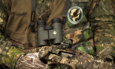image of turkey hunter with binoculars, camo gloves, and other gear