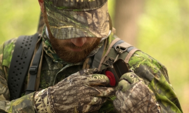 image of a hunter pulling a mouth call from his vest pocket