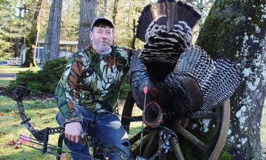 image of a successful bow hunter and his turkey