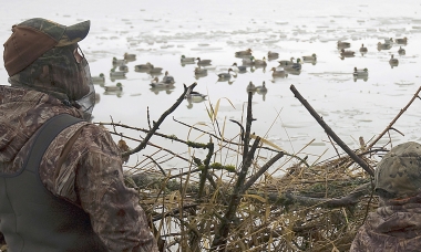 Two hunters waiting for ducks to fly into their decoy spread