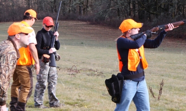 Shooter lines up a shot while instructor looks on from behind