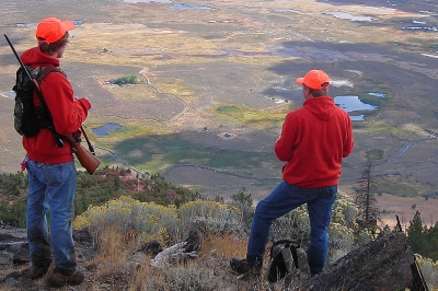 image of two deer hunters on a ridge scanning countryside