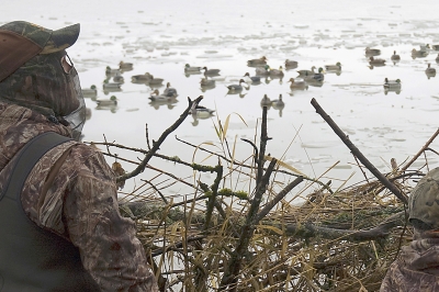 Two hunters waiting for ducks to fly into their decoy spread