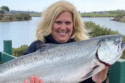 Smiling female angler with huge Chinook