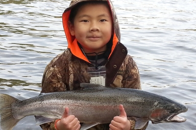 young angler gives two thumbs up for steelhead