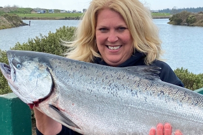 Female angler holding a huge Chinook from Winchester Bay