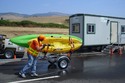 ODFW Aquatic Invasive Species Check Station spraying down kayaks on a boat trailer